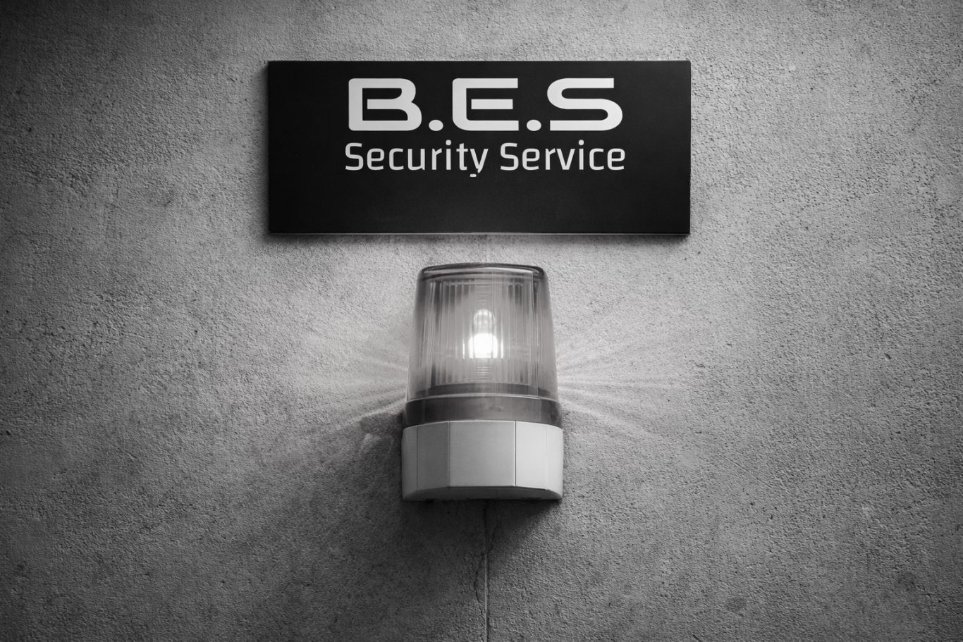 Interventionsdienst & Alarmbereitschaft B.E.S. Sicherheitsdienst Schild mit rot leuchtendem Blitzlicht auf grauem Hintergrund.